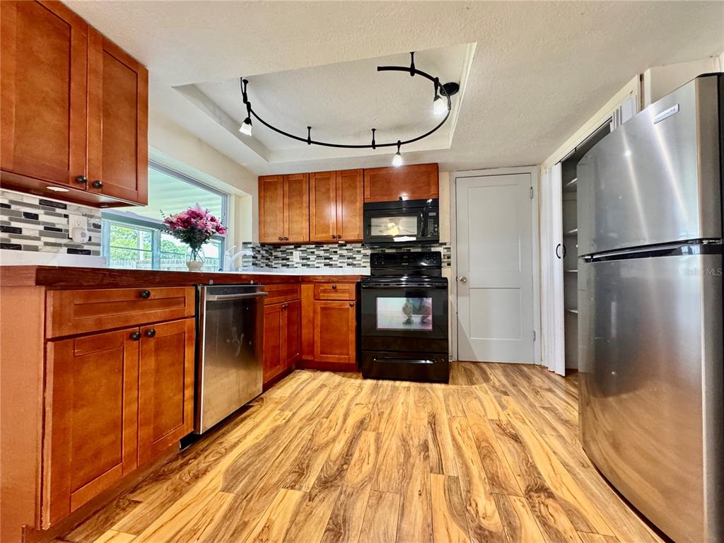 3902 Glissade Drive New Port Richey, FL 34652 - Photo 8 of 26 a kitchen with stainless steel appliances granite countertop a refrigerator and a sink