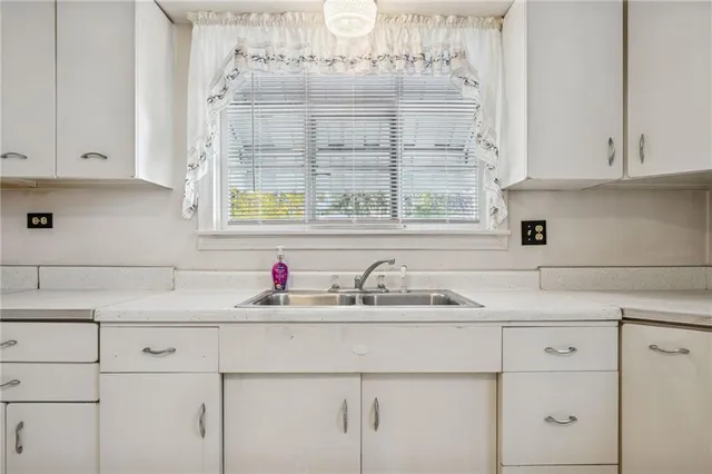 a kitchen with white cabinets and a sink