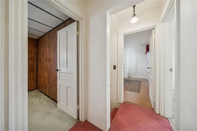 a view of a hallway with closet and a bathroom