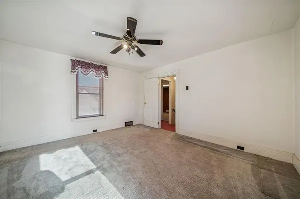 a view of a room with a empty space and ceiling fan
