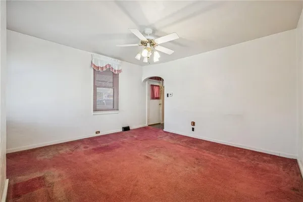 an empty room with fan and windows