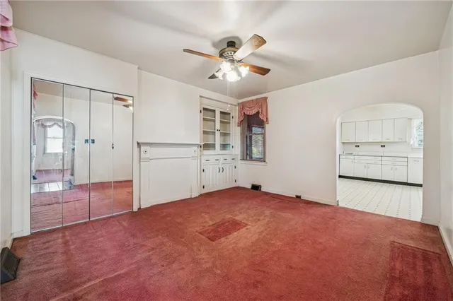 a view of an empty room with cabinet and a window