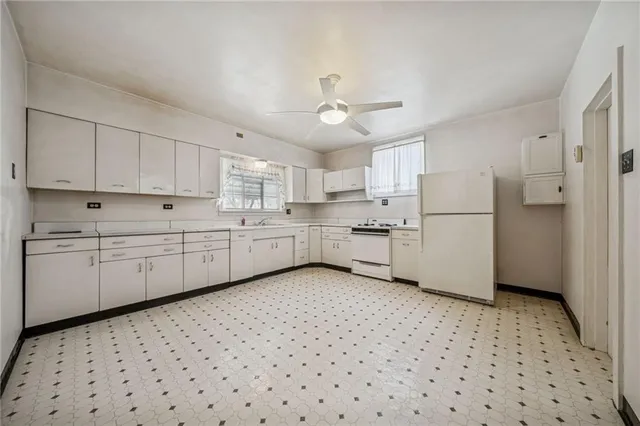 a kitchen with white cabinets a sink a stove a refrigerator and white cabinets