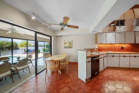 a kitchen with a stove a table and chairs in it