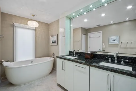 a spacious bathroom with a double vanity sink a mirror and a bathtub