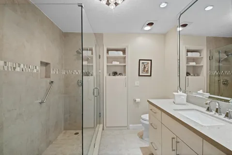 a spacious bathroom with a shower sink and mirror