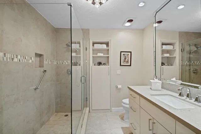a spacious bathroom with a shower sink and mirror
