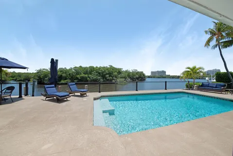a view of a swimming pool with a yard and sitting area