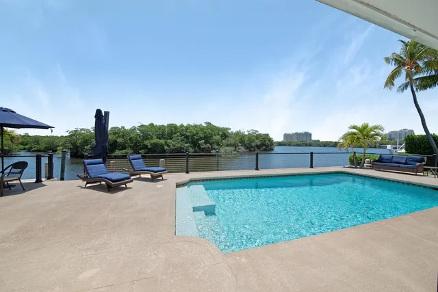 a view of a swimming pool with a yard and sitting area