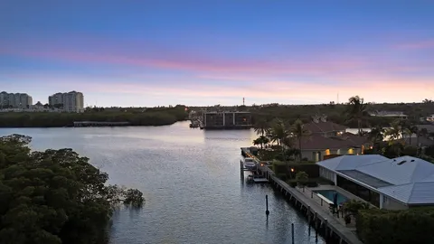 a view of a big house with a big yard plants and large trees