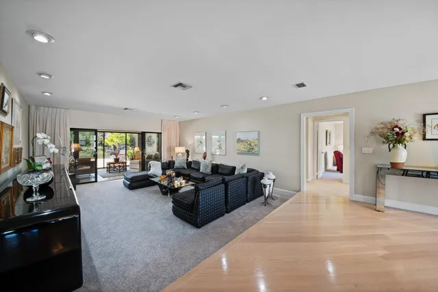 a living room with furniture large window and potted plant