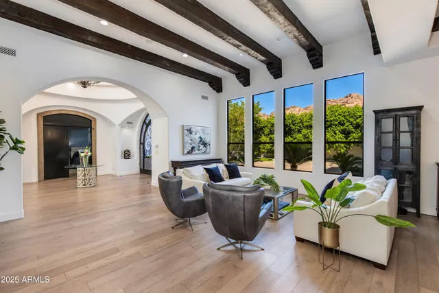a living room with furniture fireplace and large windows
