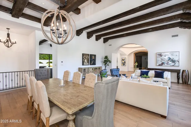 a living room with couches a dining table and chairs with a bookshelf