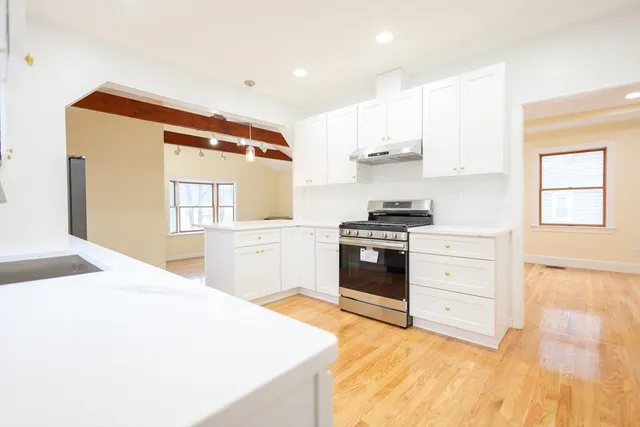 a kitchen with stainless steel appliances kitchen island granite countertop a refrigerator and a stove top oven