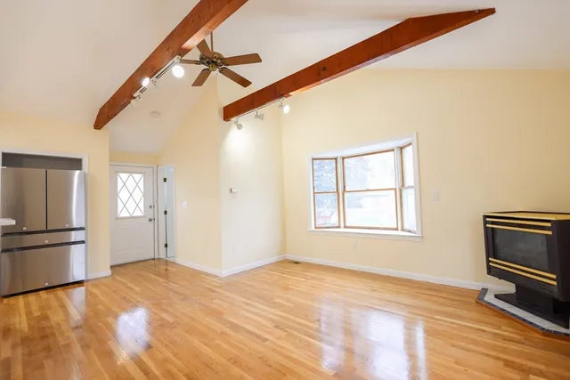 a view of a kitchen with wooden floor and a refrigerator