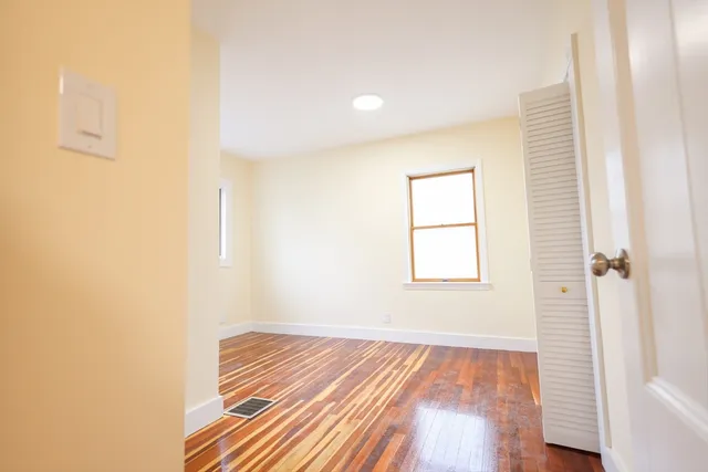 a view of a room with wooden floor and a window