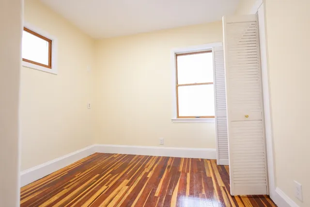 a view of a room with wooden floor and a window