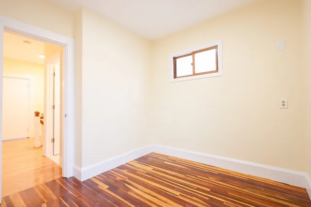 a view of a room with wooden floor and a ceiling fan
