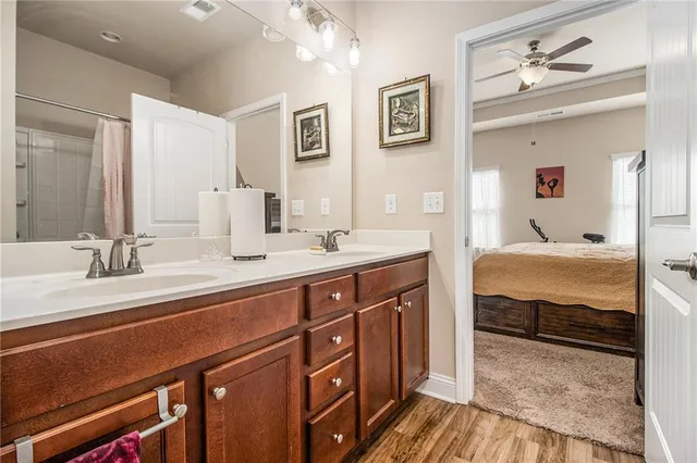a en suite bathroom with double vanity sinks a vanity and a large mirror