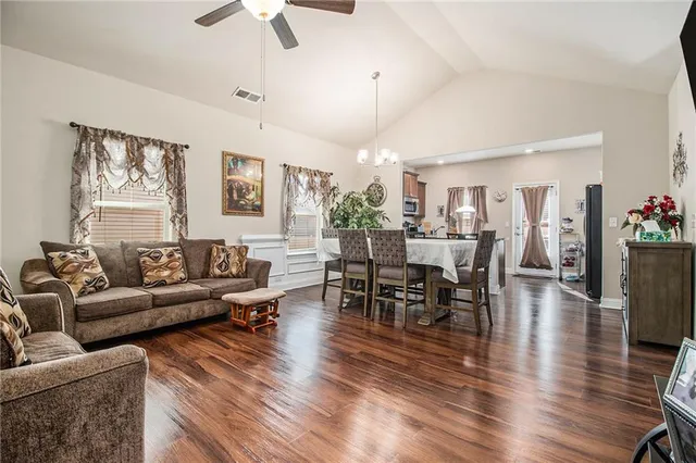 a living room with furniture dining area and a chandelier