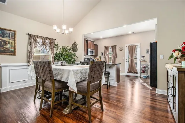 a dining room with furniture a chandelier and wooden floor