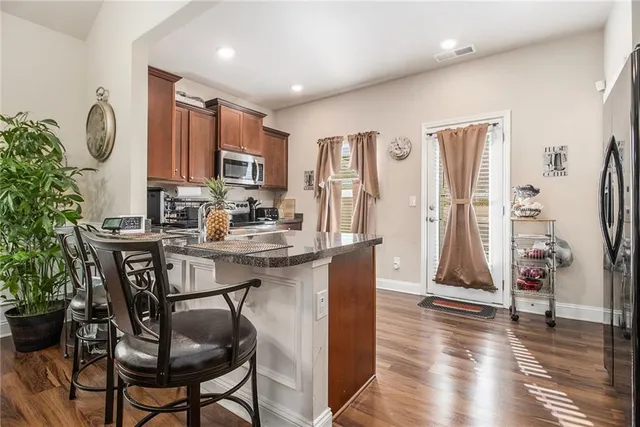 a open kitchen with stainless steel appliances granite countertop a stove top oven a sink and cabinets