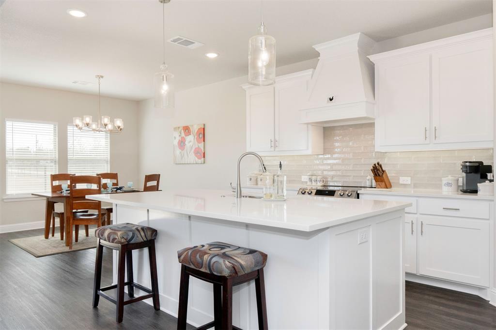 849 County Road 4764 Boyd, TX 76023 - Photo 10 of 40 a kitchen with white cabinets and chairs