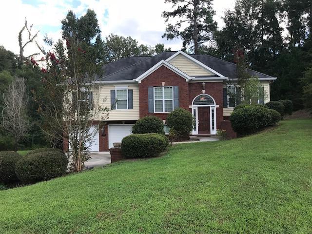 a front view of a house with a yard and trees