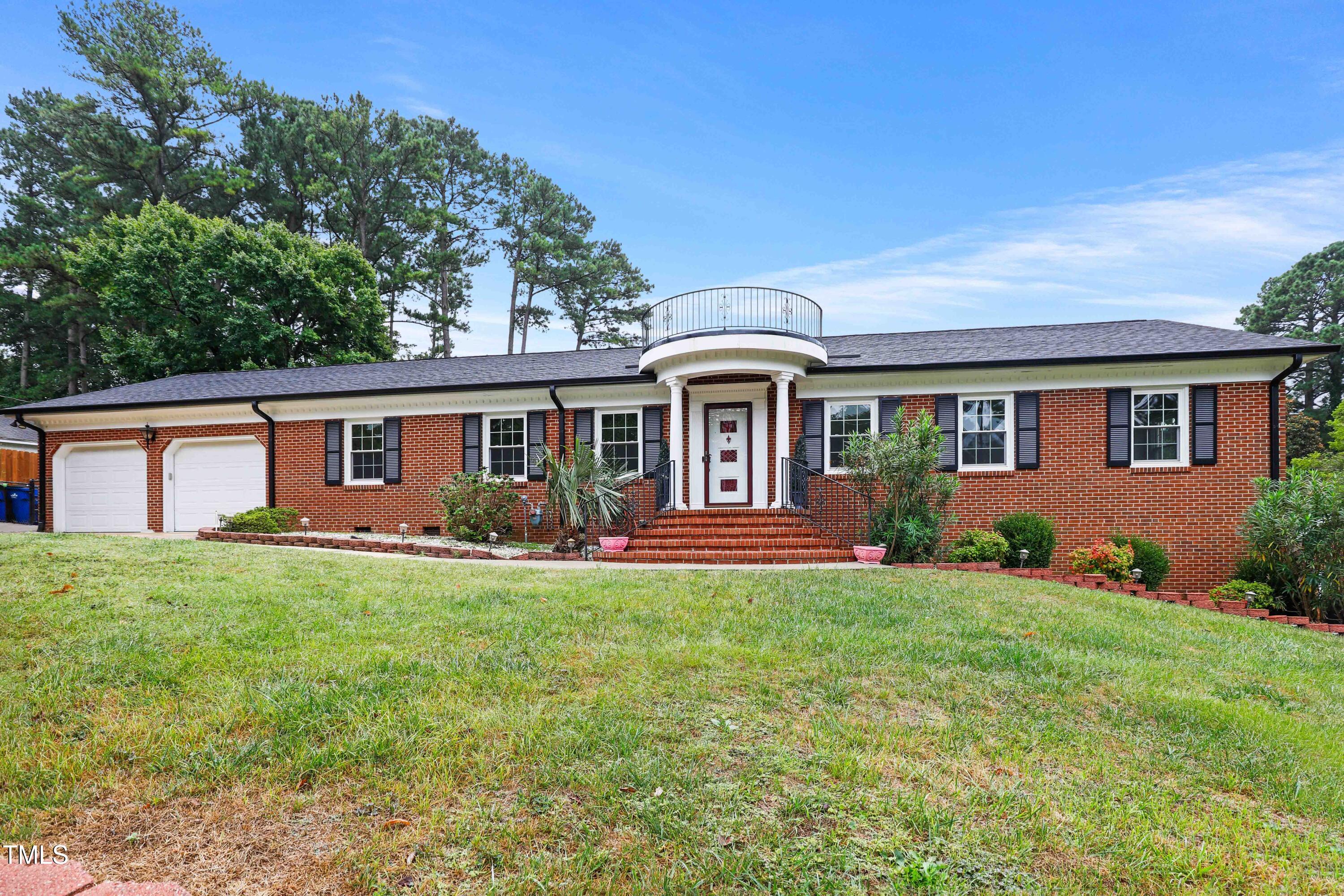 a front view of a house with a garden