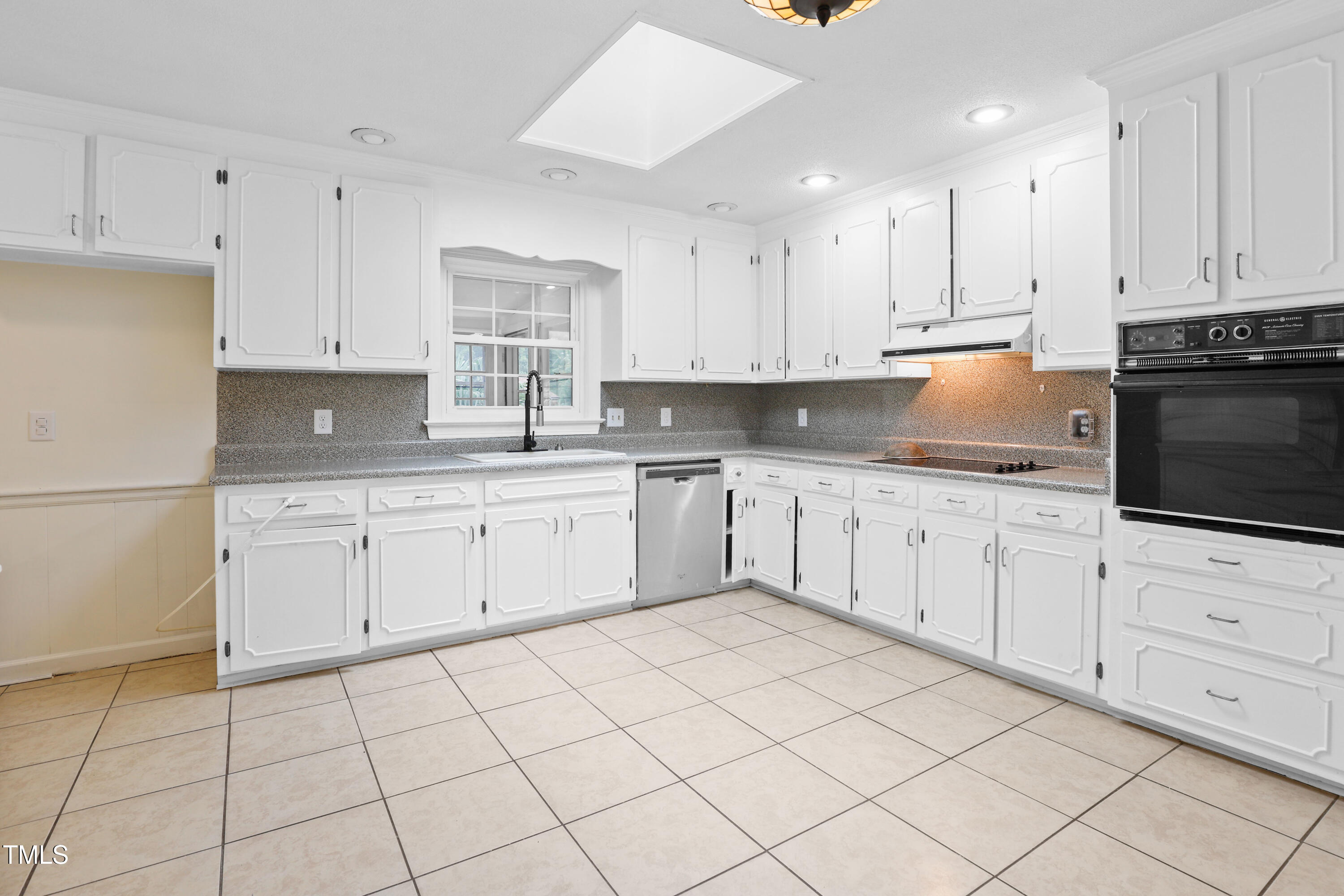 1204 Country Ridge Drive Raleigh, NC 27609 - Photo 5 of 49 a kitchen with white cabinets stainless steel appliances and a sink