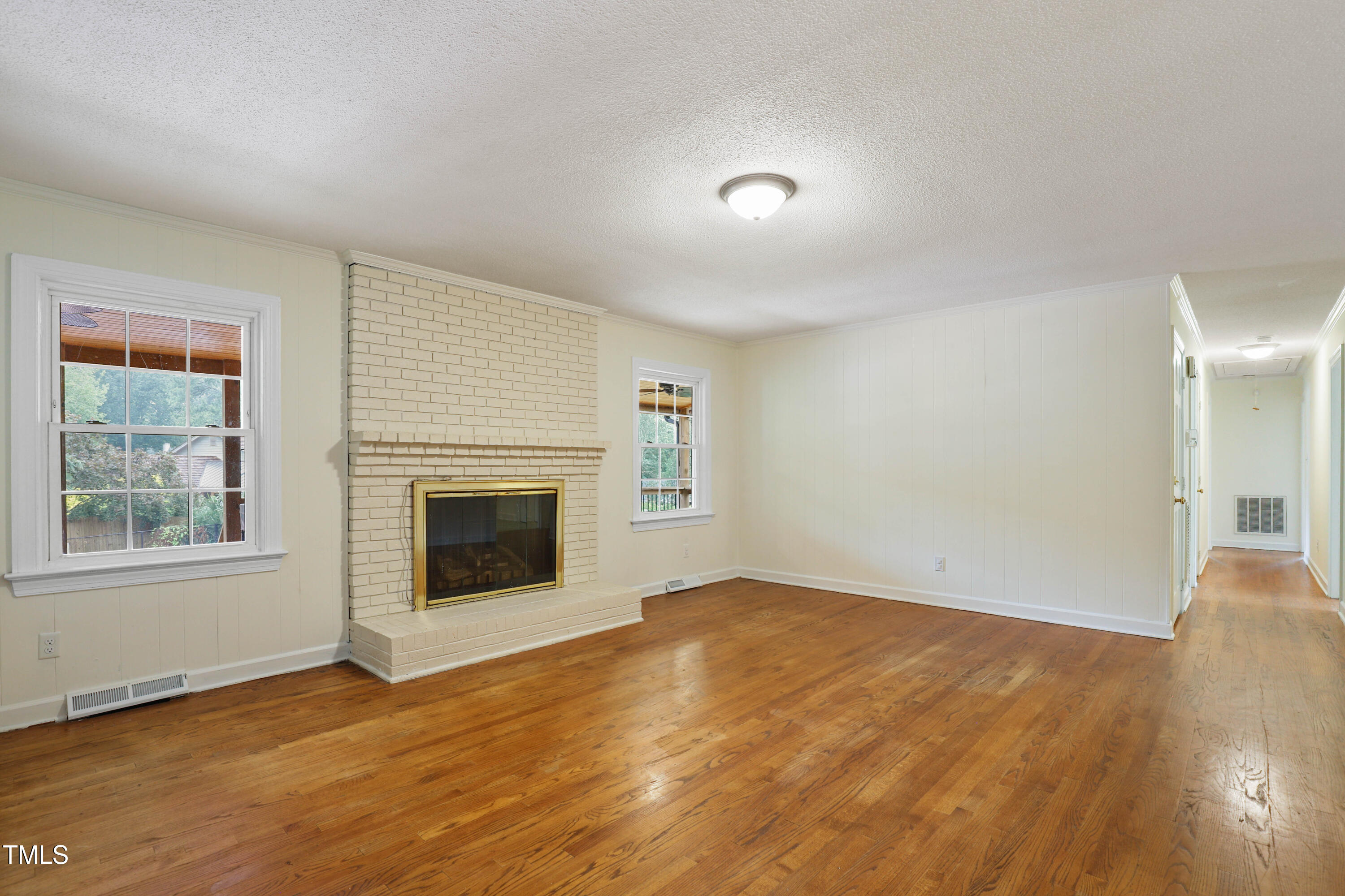 1204 Country Ridge Drive Raleigh, NC 27609 - Photo 7 of 49 an empty room with wooden floor fireplace and windows