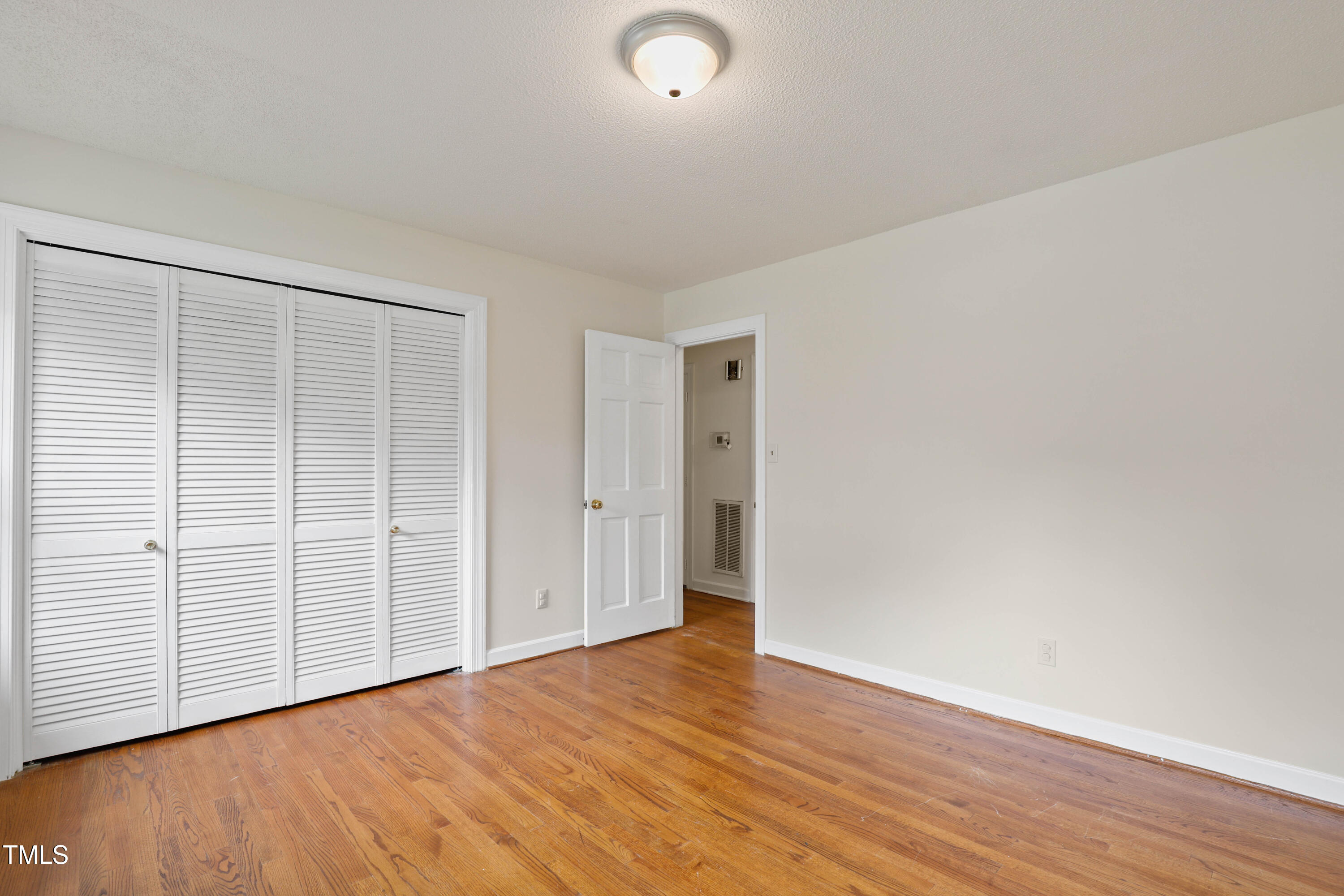 1204 Country Ridge Drive Raleigh, NC 27609 - Photo 10 of 49 a view of an empty room with wooden floor