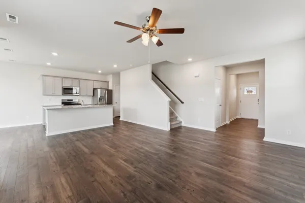 a view of a kitchen with wooden floor and a ceiling fan