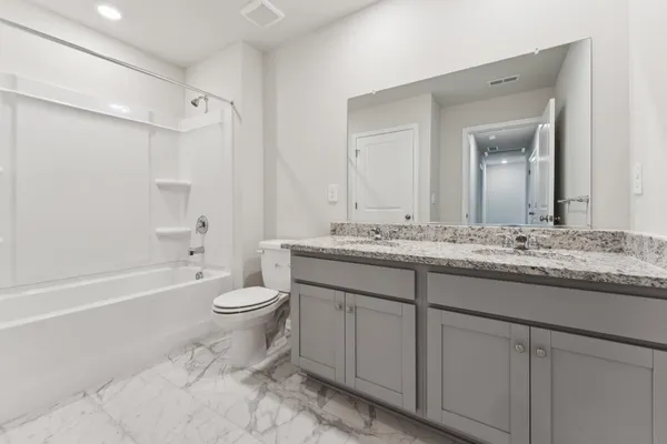 a bathroom with a granite countertop sink toilet and shower