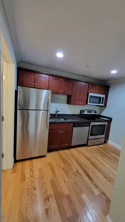 a kitchen with stainless steel appliances granite countertop a refrigerator a sink and a stove