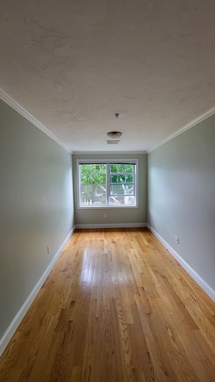 277 Pawtucket Street, Unit 2C Lowell, MA 01854 - Photo 8 of 16 an empty room with wooden floor and windows