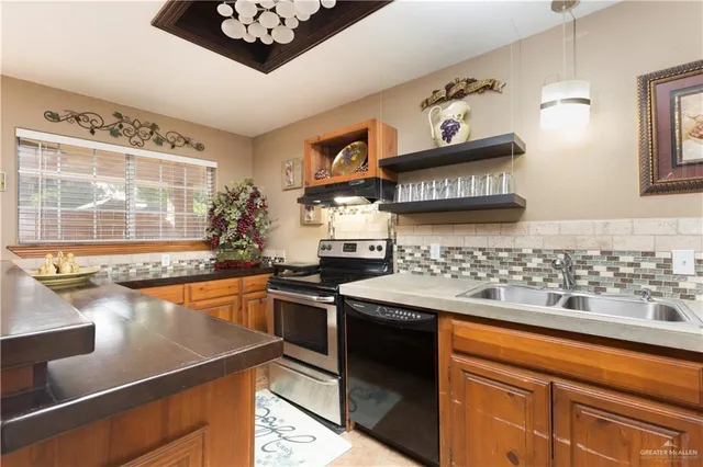 a kitchen with stainless steel appliances granite countertop a sink stove and cabinets