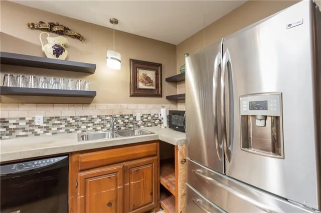 a kitchen with stainless steel appliances granite countertop a refrigerator and a sink