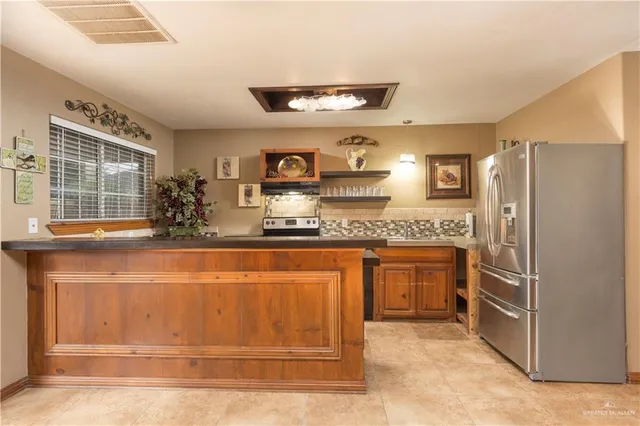a kitchen with stainless steel appliances granite countertop a refrigerator and a sink