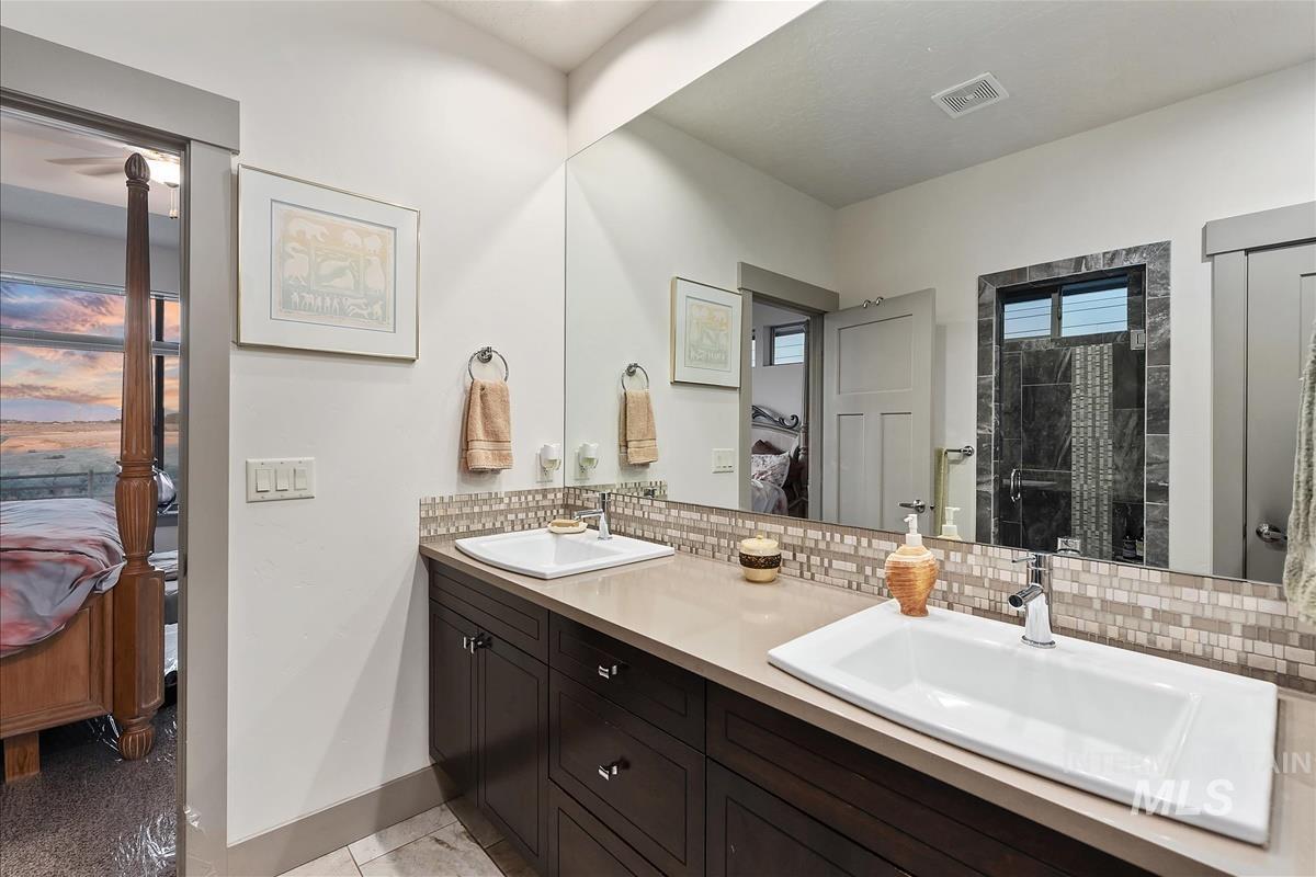 24398 Tombstone Ridge Court Middleton, ID 83644 - Photo 19 of 48 Dual vanity with drop-in sinks, polished chrome fixtures, and a mosaic tile backsplash