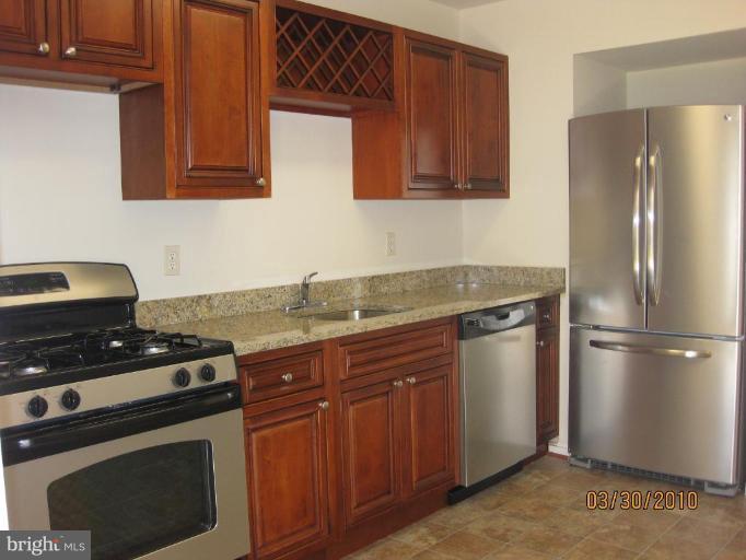 667 South Wickham Road Baltimore, MD 21229 - Photo 3 of 11 a kitchen with granite countertop a stove microwave and refrigerator