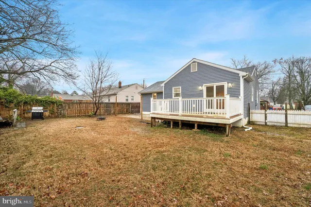 a white house that has a small yard and a large tree