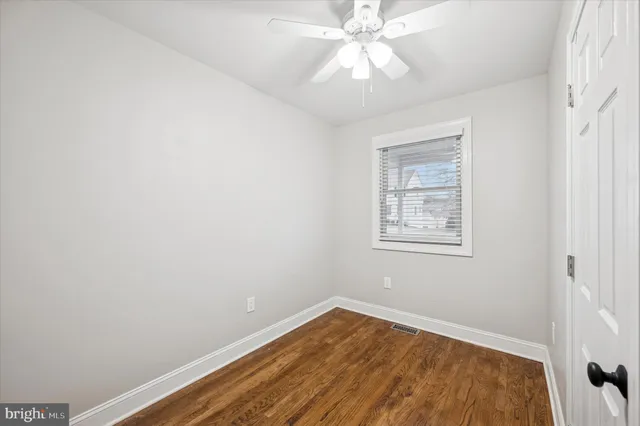 an empty room with a window and a fan