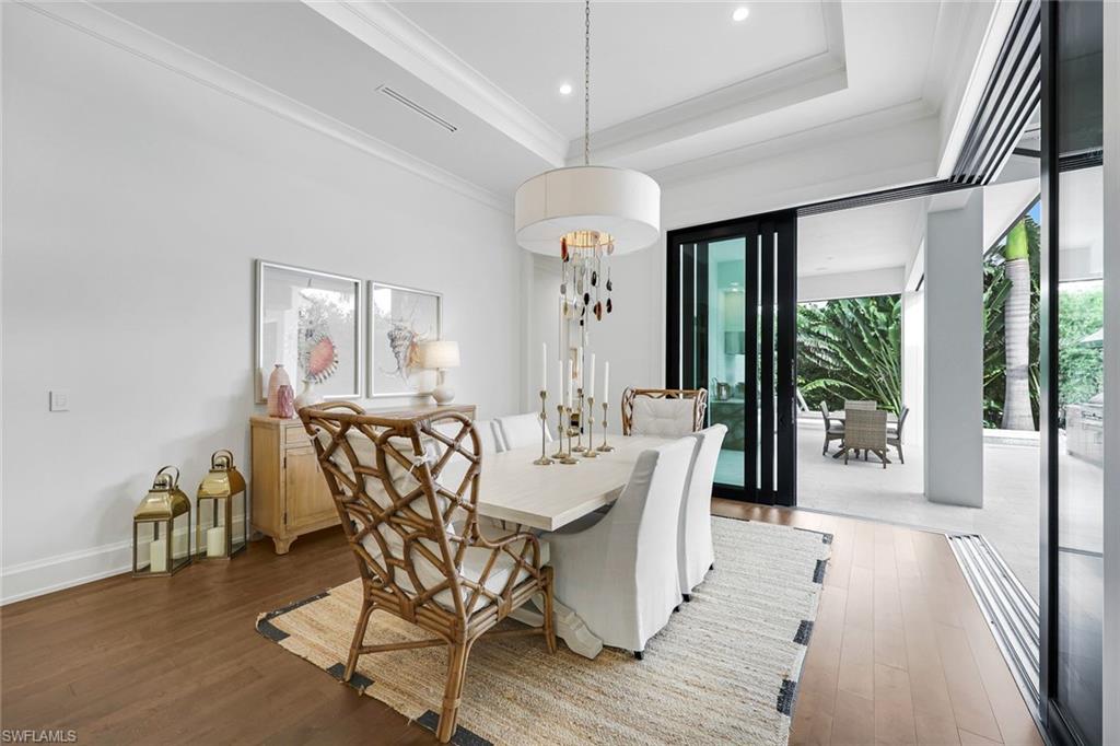 3200 Crayton Road Naples, FL 34103 - Photo 11 of 30 a view of a dining room with furniture wooden floor and chandelier