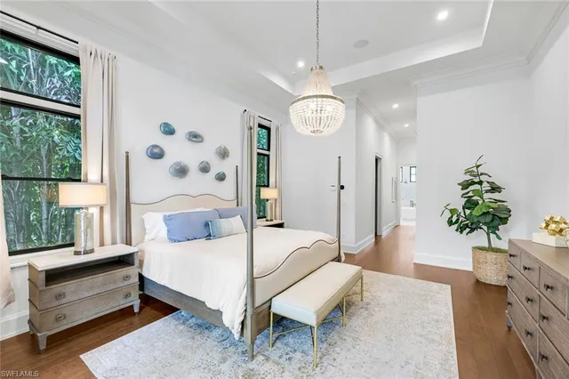 a bedroom with a bed and a chandelier