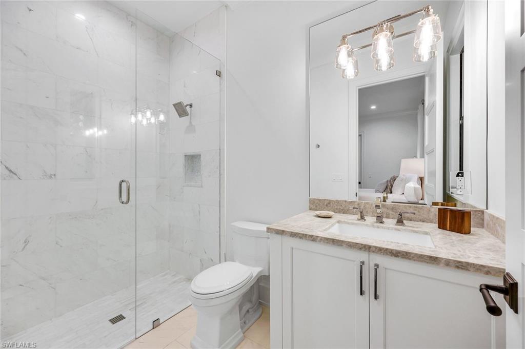3200 Crayton Road Naples, FL 34103 - Photo 18 of 30 a bathroom with a sink a toilet and shower