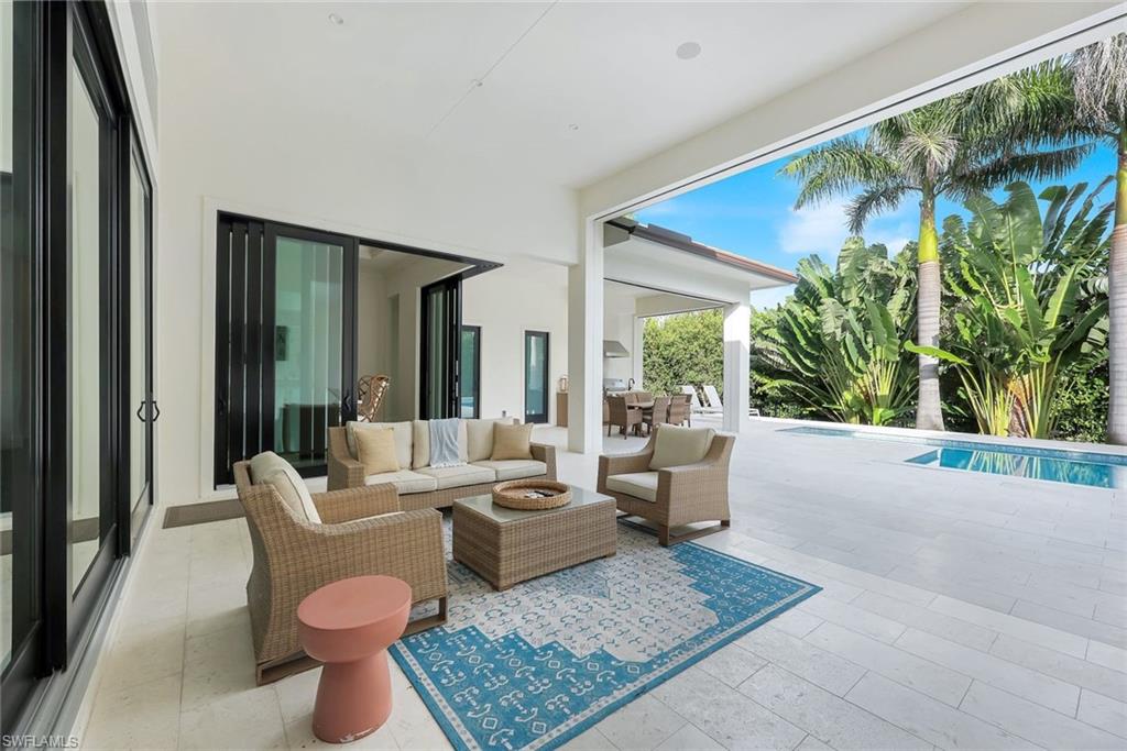 3200 Crayton Road Naples, FL 34103 - Photo 26 of 30 a living room with patio furniture and a potted plant