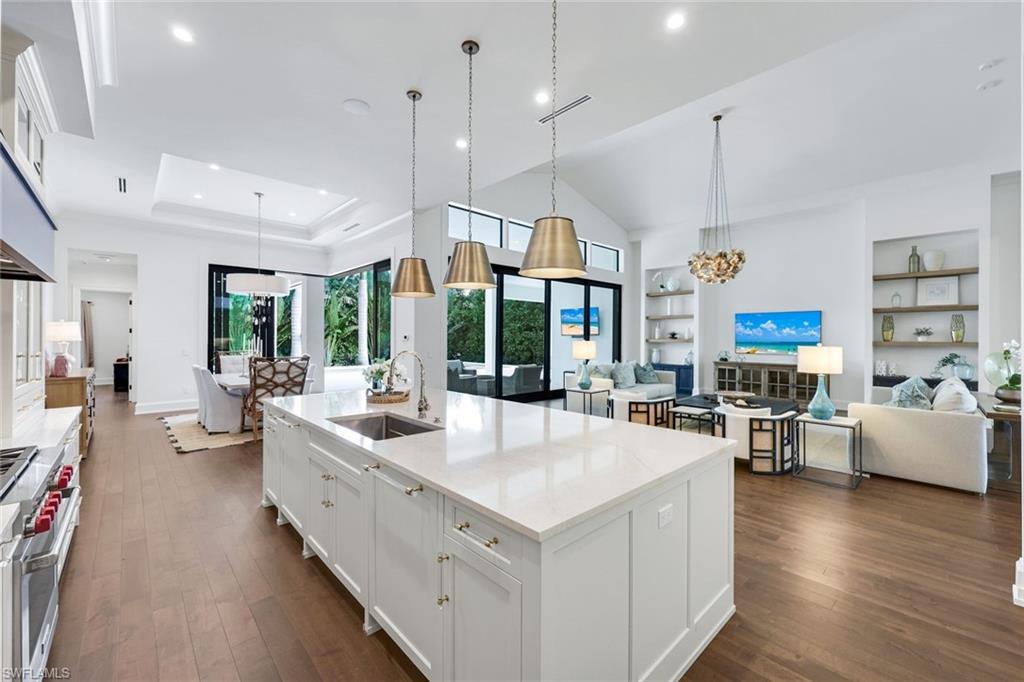 3200 Crayton Road Naples, FL 34103 - Photo 9 of 30 a large kitchen with stainless steel appliances kitchen island granite countertop a large island in the center