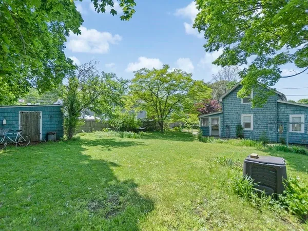 a backyard of a house with table and chairs