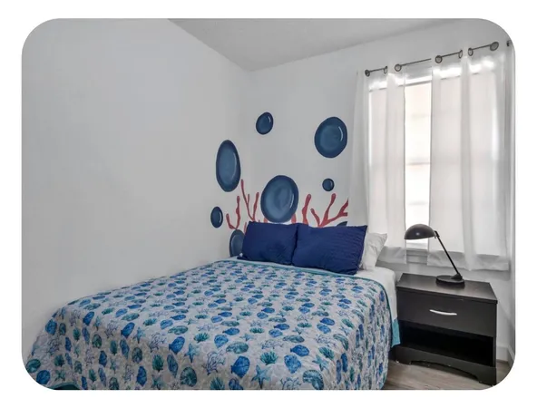a bedroom with a bed and a painting on the wall